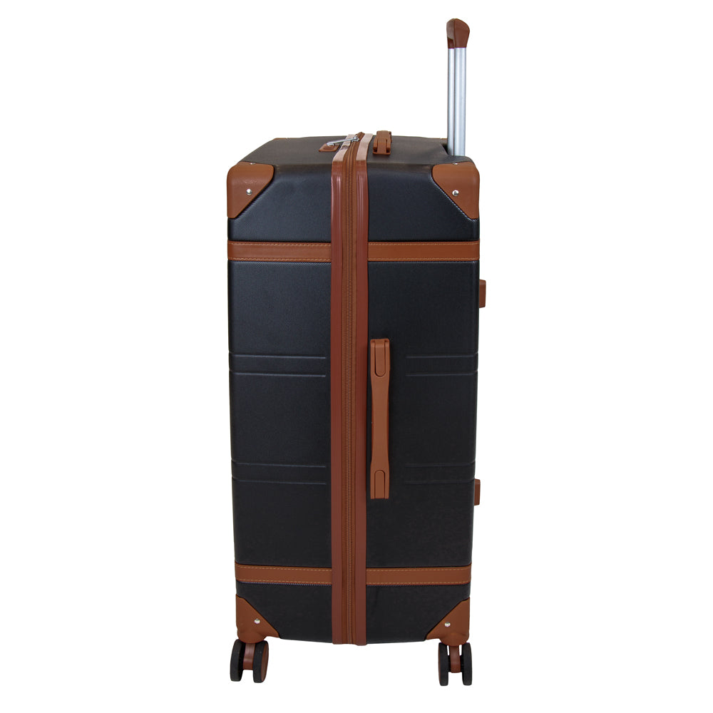 Side profile of the Skyflite Retro XL Trunk suitcase in black, showing the classic hardshell design, tan vintage-style trim, and eight spinner wheels.